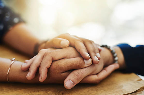 Two people holding hands across a table